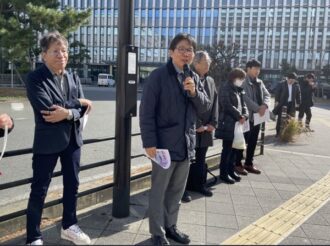 全国の訴訟の状況を報告する田久労対部長（門前集会）