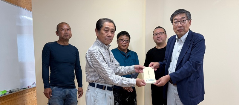 熊建労本部を訪れ、義援金を林副委員長に手渡す隈本委員長